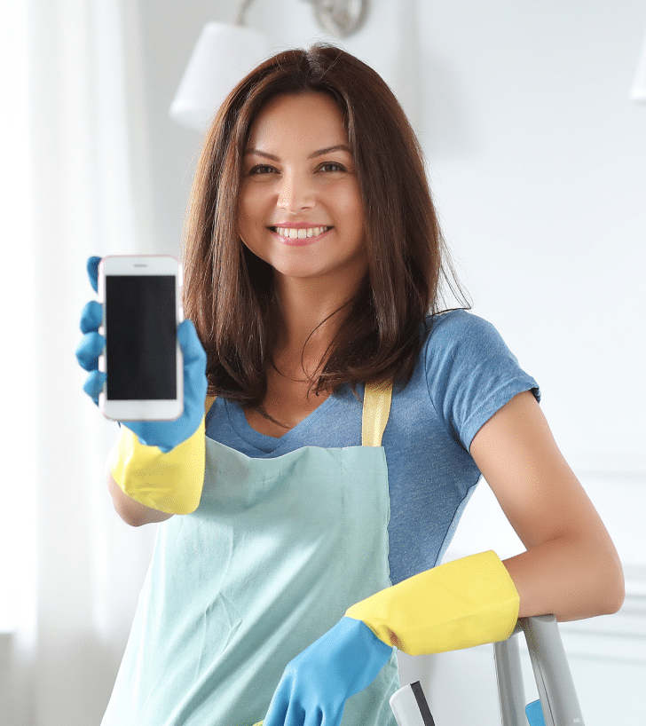 a1baf24f young woman with rubber gloves showing smartphone 1 e1654295084742